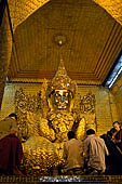 Applying gold leaf to statue at Mahamuni Pagoda, Myanmar 